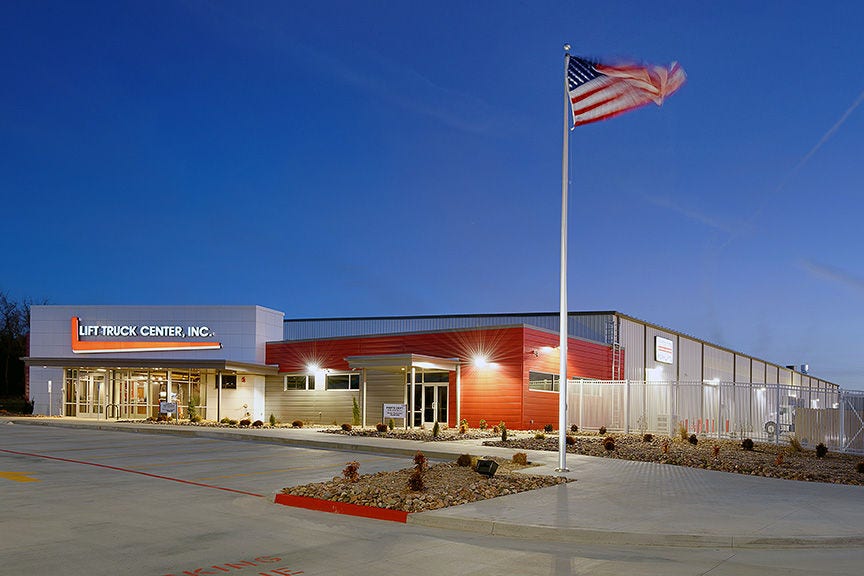 white and red building with the American Flag flying on a flag pole