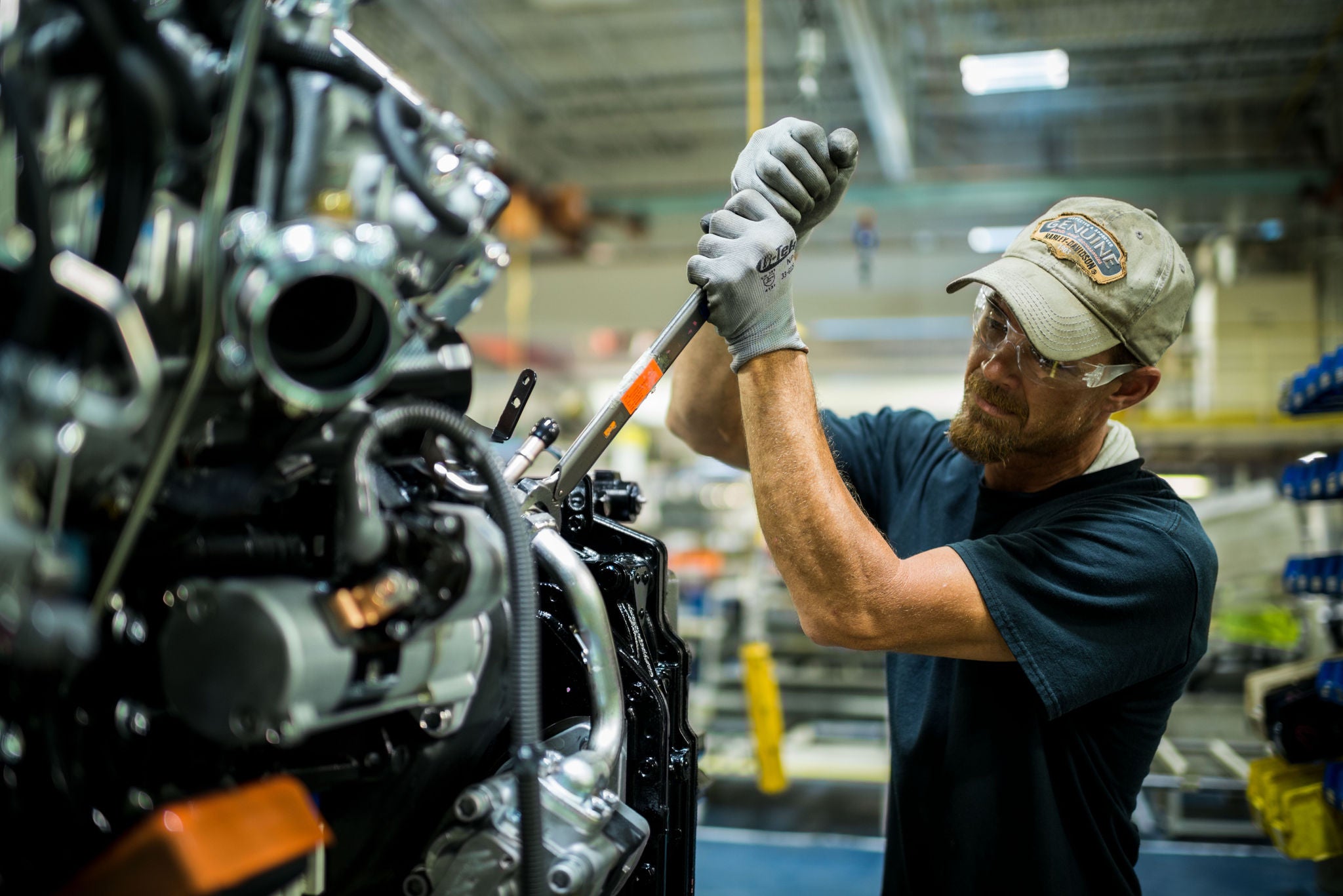 toyota associate working on forklift engine with tool